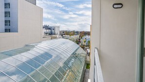 Un edificio moderno con fachada de vidrio curva y vista del área urbana circundante.