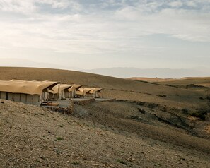 A desert landscape with multiple tents arranged in a row. - Caravan by Habitas Agafay (Agafay)