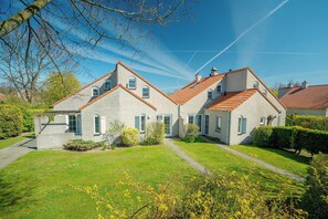 A row of three-story houses with a well-maintained lawn and clear skies. - Easygoing Garden Stay in Brouwershaven (Brouwershaven)