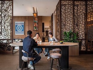 A modern interior with a round bar area, seating, and decorative panels. - JEN Kunming by Shangri-la (Kunming)