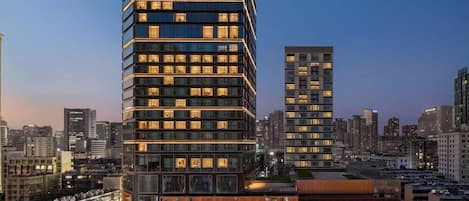 A modern hotel with a prominent 'SHANGRI-LA' sign, multiple floors, and a well-lit facade.