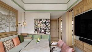 A living room with a sofa, a dining table, and a bookshelf. - JEN Kunming by Shangri-la (Kunming)