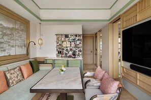 A living room with a sofa, a dining table, and a bookshelf. - JEN Kunming by Shangri-la (Kunming)