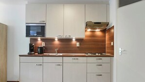 Eine moderne Küche mit integrierten Geräten, einer Holz Arbeitsplatte und weißen Schränken.