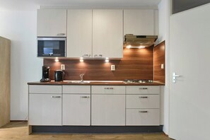 Eine moderne Küche mit integrierten Geräten, einer Holz Arbeitsplatte und weißen Schränken.