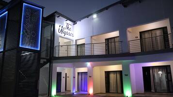 A multi-story hotel with balconies and a sign reading 'The Ulysses.'