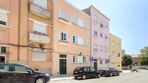 A row of multi-story buildings with parking spaces and a street. - GuestReady-Charming 3-Bedroom Lisbon Retreat (Lisbon)