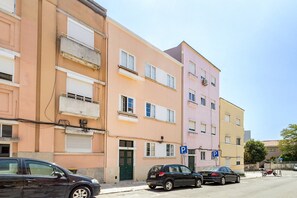A row of multi-story buildings with parking spaces and a street. - GuestReady-Charming 3-Bedroom Lisbon Retreat (Lisbon)