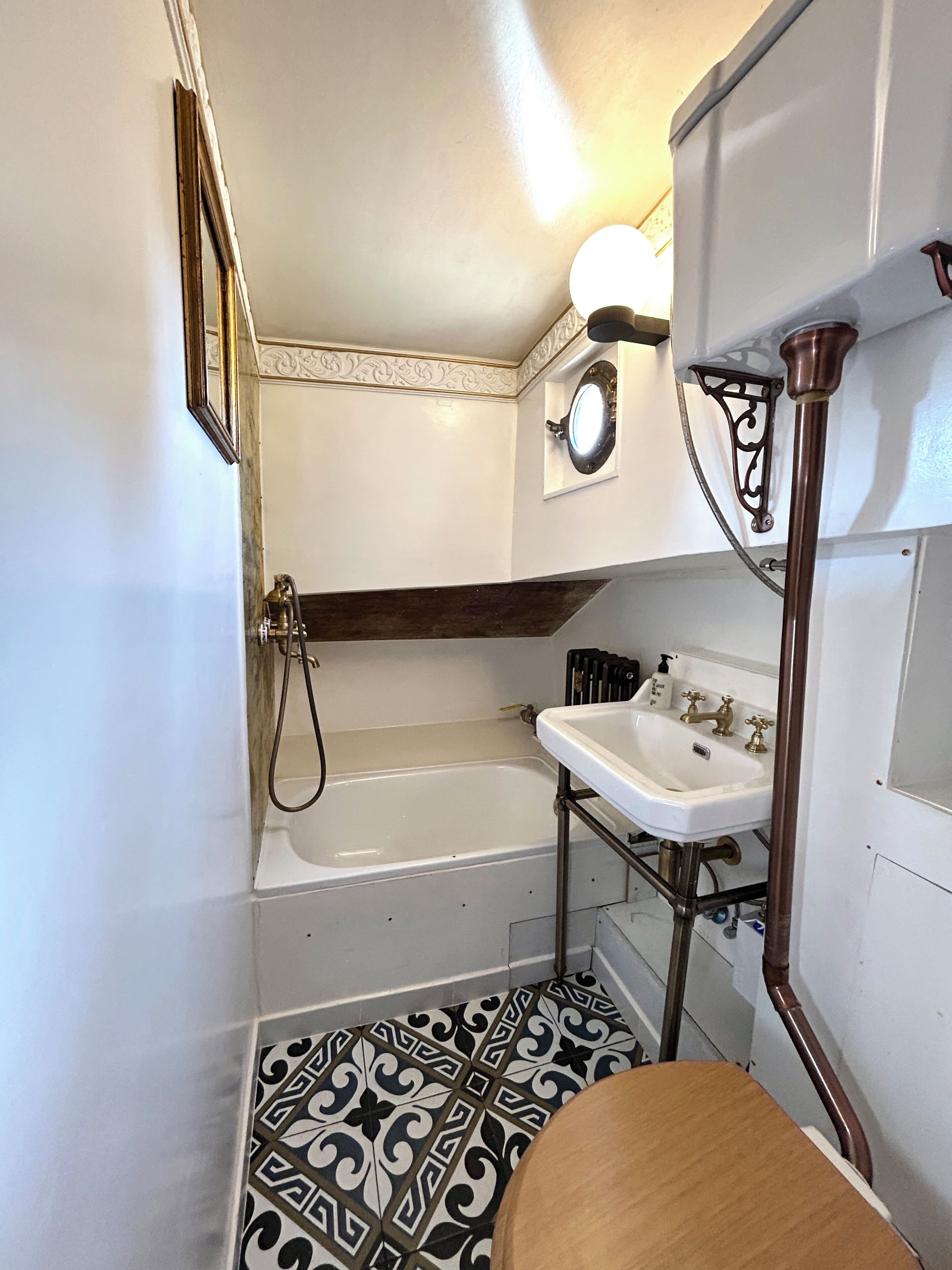 Ein kleines Badezimmer mit Badewanne, Waschbecken und Toilette.