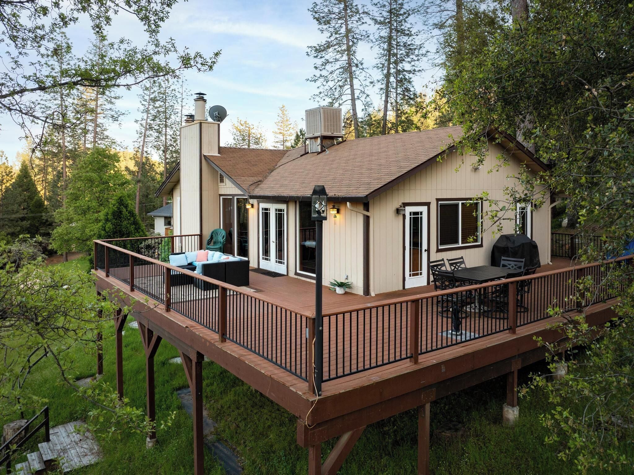 Una casa con terraza, patio cubierto y chimenea.
