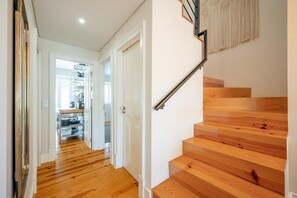Eine Holztreppe mit Handlauf und einer Wanddekoration aus Makramee.