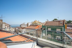 Ein Hochhaus mit mehreren Balkonen und freiem Blick auf das Meer.