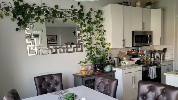 A dining area with a table, chairs, and a kitchen in the background. - Rapperswill Serenity (Edmonton)