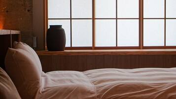 A room with a bed, a window with a view, and a hanging light fixture.