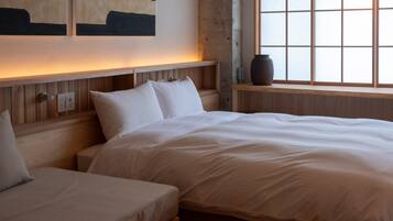 Un dormitorio con una cama grande, una cama más pequeña y una ventana con vistas.