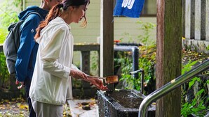 Una persona usando una bomba de agua tradicional al aire libre.