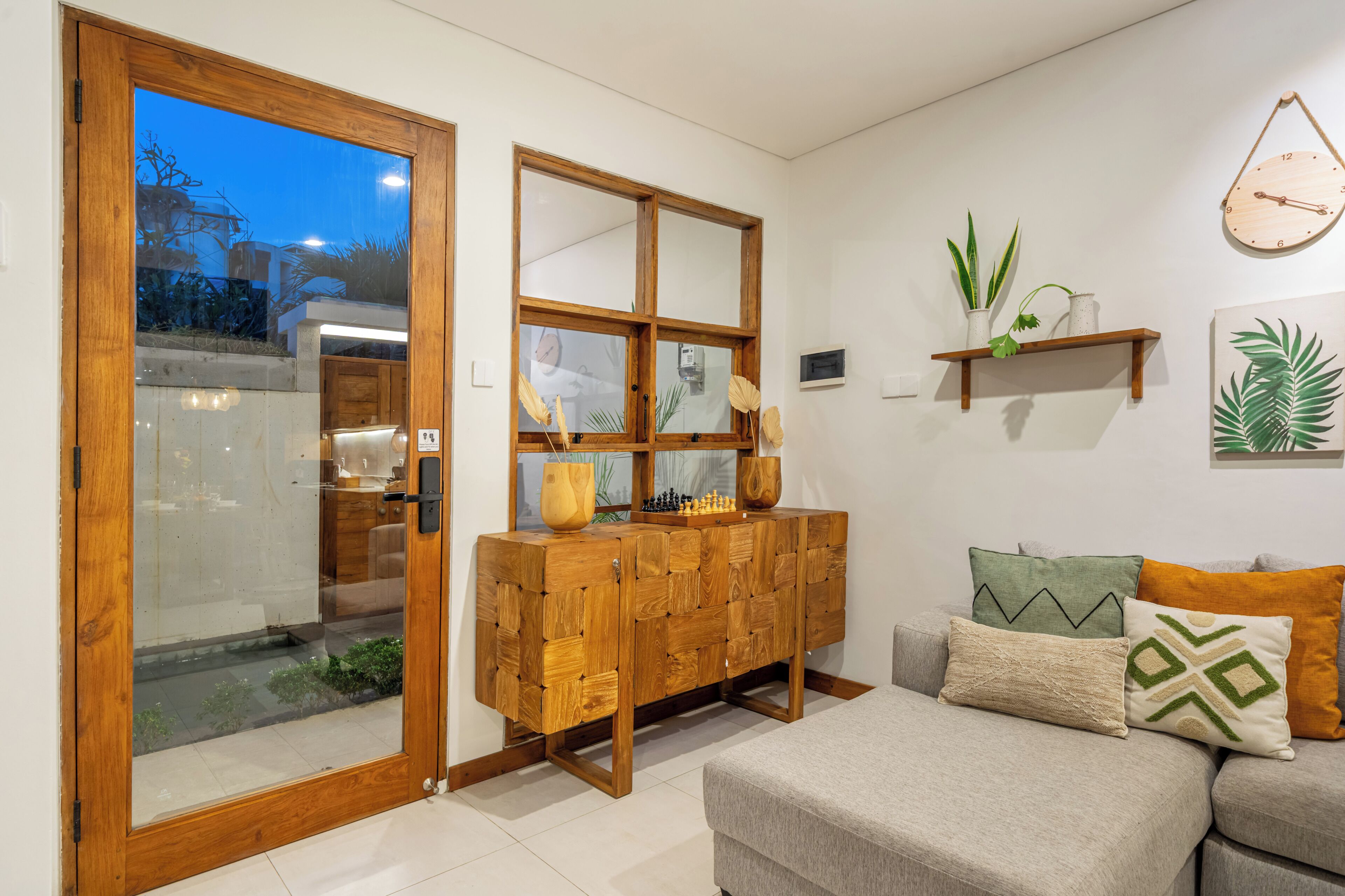 Ein modernes Wohnzimmer mit einem Holzkasten, einer Couch und einer Wanduhr.