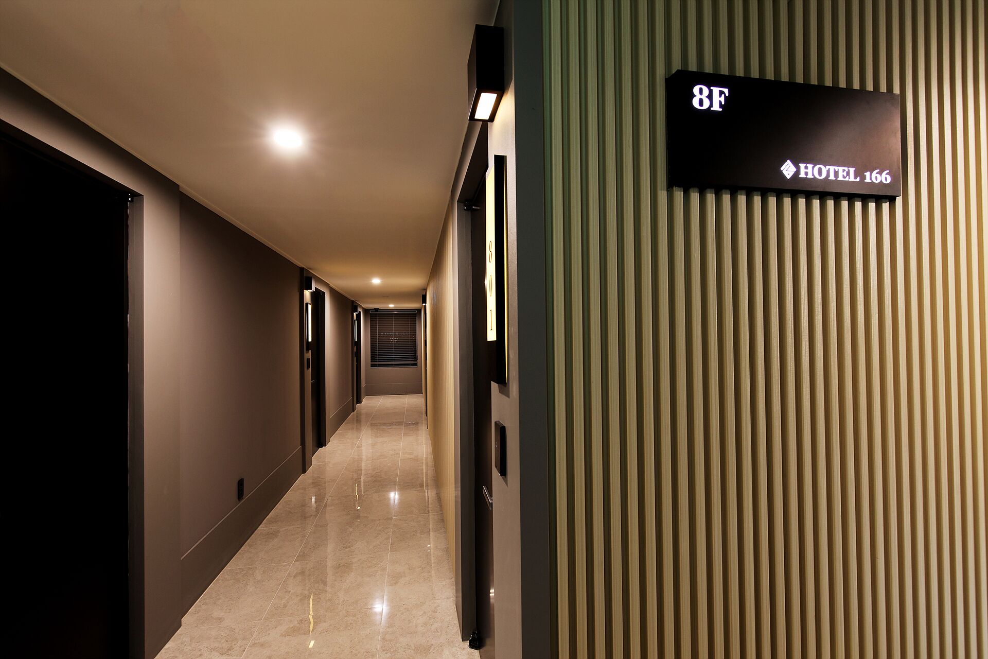 Un couloir d’hôtel avec une pancarte indiquant la chambre 8F et le nom de l’hôtel.