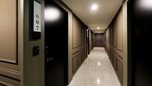 Pasillo de hotel con puertas numeradas 607 y 6077, que dan a las habitaciones.