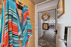 A door with a frosted glass panel, a circular sign with text, and a framed picture. - Beachfront Burleigh Getaway! (Gold Coast)