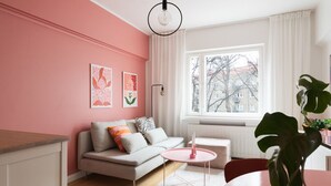 Een moderne woonkamer met een bank, een ronde tafel en een groot raam.