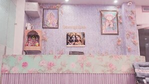 A room with a decorative wall, a ceiling fan, and a patterned floor. - Laxmi Seva Sadan Laxmi Hotel  (Barsana)
