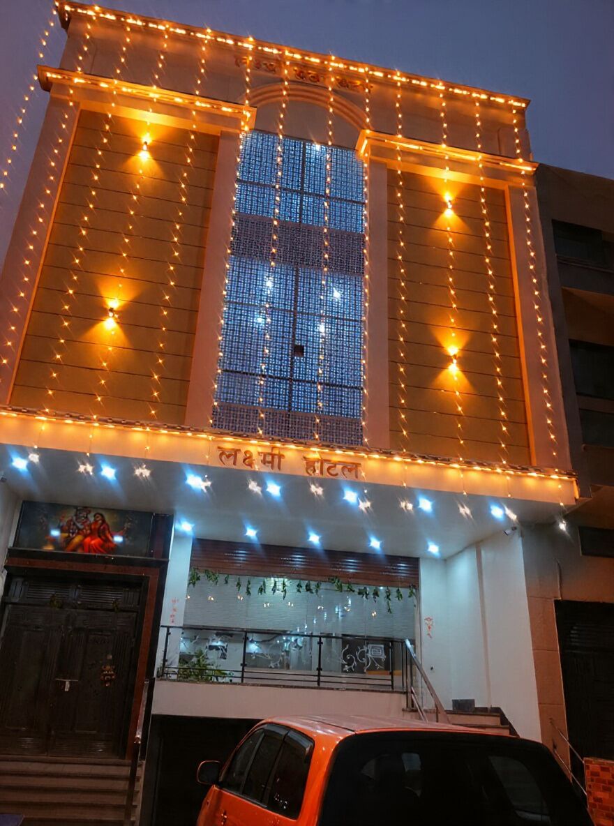 A building with a large glass facade, a staircase leading to the entrance, and a sign with text.