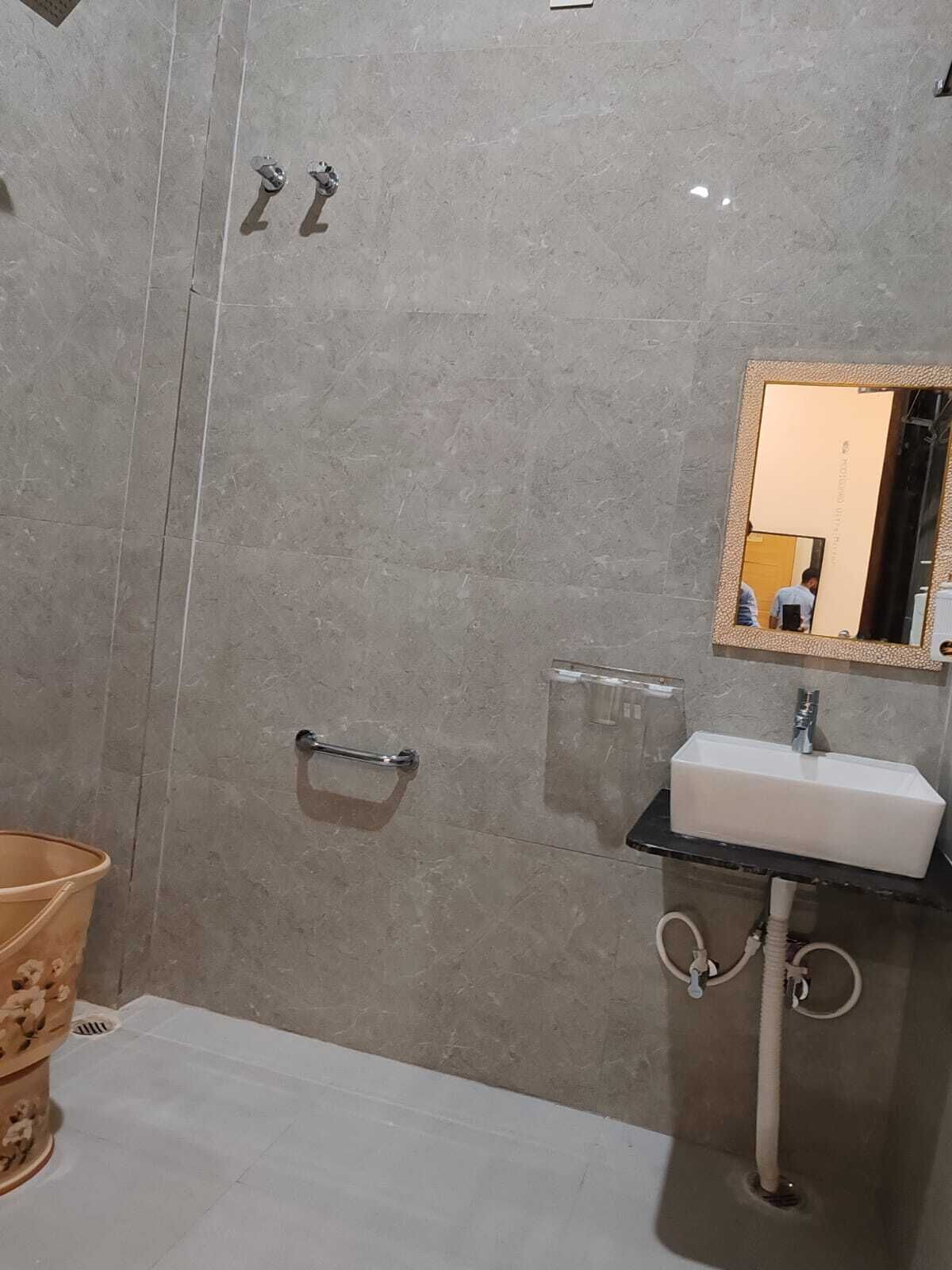 Une salle de bain avec un lavabo blanc, un miroir et un porte-serviettes.