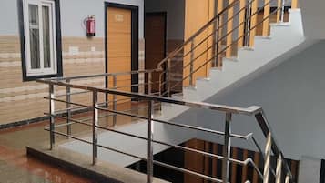 A modern interior with a staircase, a fire extinguisher, and a door labeled 'Robe'.