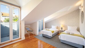 Een moderne hotelkamer met twee bedden, een balkon en een wand met een steegverbandpatroon.