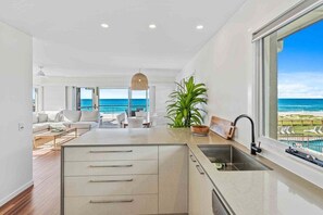 A modern kitchen with a view of the ocean, a dining area with a view, and a large window. - 8 / 39 Albatross Avenue (Gold Coast)