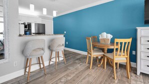 Una cocina moderna con armarios blancos, un refrigerador de acero inoxidable y una pared de acento azul.