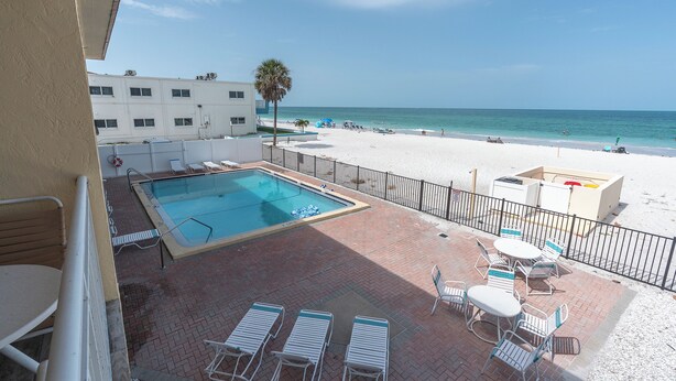 Zona de piscina con vista a la playa y al océano.