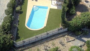 Et moderne hus med swimmingpool, overdækket terrasse og en velholdt have.