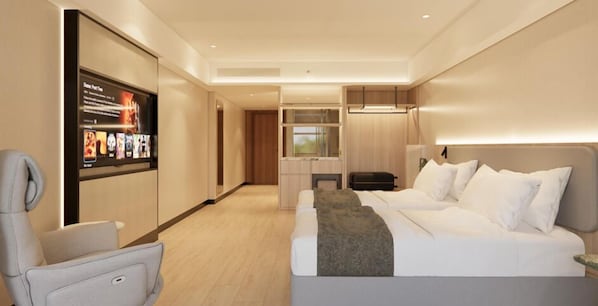 A modern hotel room with a bed, a seating area, a television, and a fireplace.