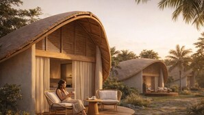 A resort with overhanging wooden structures, a paved outdoor area with seating, and a tropical environment. - Vikasa Evolution Retreat Phuket (Koh Lon)