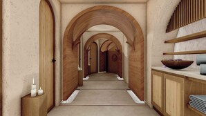 A hallway with wooden arches, a wooden bench, a bowl on a counter, and a small table with candles. - Vikasa Evolution Retreat Phuket (Koh Lon)