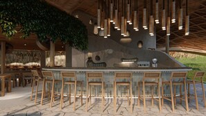 A bar area with a stone counter, wooden chairs, and hanging bamboo lights. - Vikasa Evolution Retreat Phuket (Koh Lon)