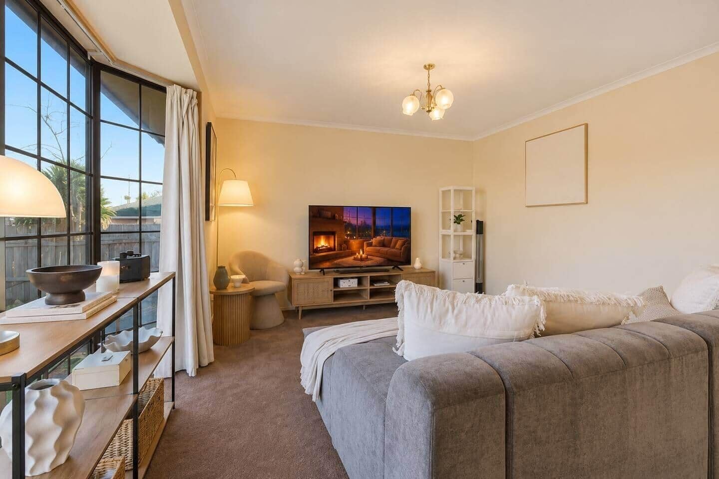 Bright and spacious living room with Smart TV, comfortable lounge and natural light.