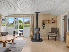 Ein gemütliches Wohnzimmer mit Kaminofen, Esstisch, Sofa und Sessel.