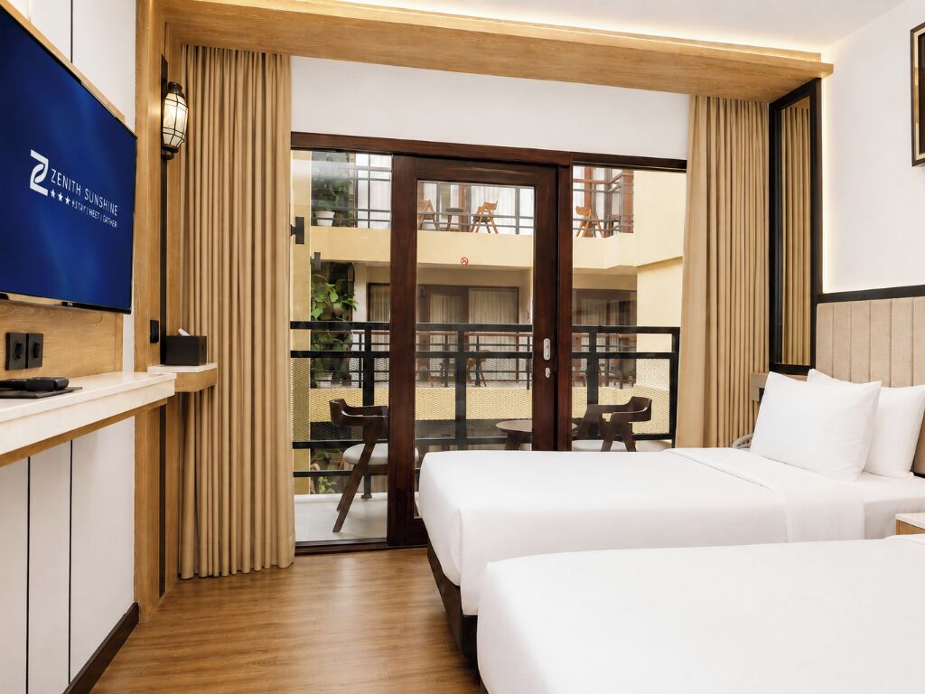 Una habitación de hotel con balcón, televisión y cama.