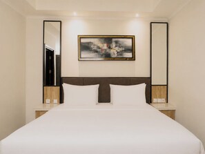 A hotel room with a large bed, two bedside tables, a headboard, and a framed abstract painting on the wall. - Zenith Sunshine (Soreang)