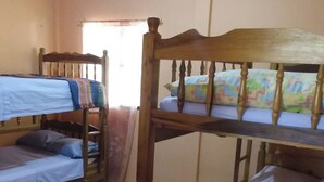 A dormitory room with bunk beds, tiled flooring, and a window with curtains. - Room-el Zonte Tiki Backpacker Beds & O (Chiltiupan)