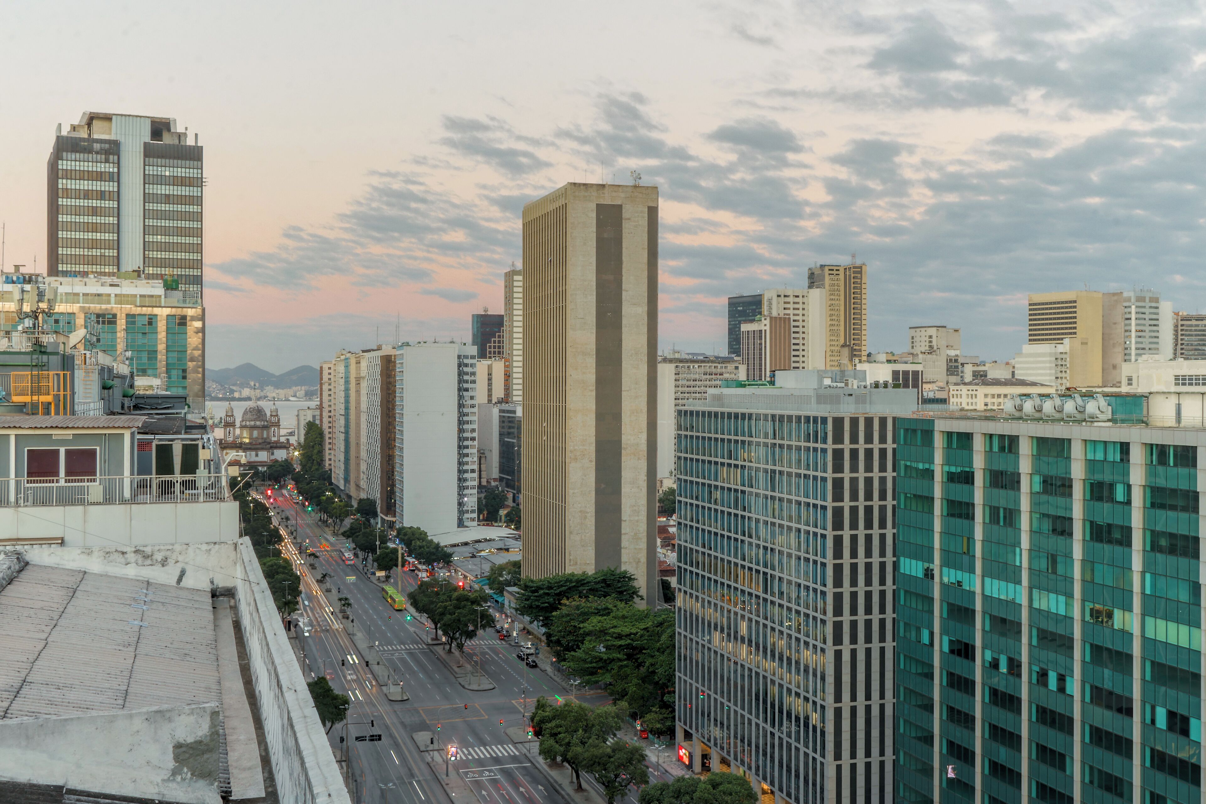 Un paysage urbain avec de hauts immeubles, une large rue et un ciel dégagé.