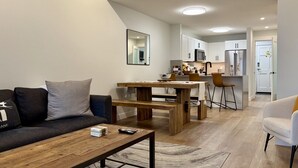 Ein modernes Wohnzimmer mit Sofa, Couchtisch und Essbereich.