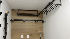 Ein Zimmer mit Holzboden, einem schwarzen Metallgestell und einer weißen Wand.