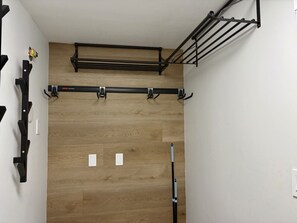 Ein Zimmer mit Holzboden, einem schwarzen Metallgestell und einer weißen Wand.