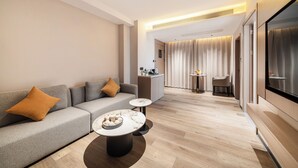 Una sala de estar moderna con un sofá, una mesa de centro y una cocina al fondo.