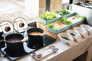Montaje tipo bufé con diversos alimentos y equipo de cocina.