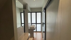 Un baño moderno con piso de madera, un lavamanos y un ventanal grande.